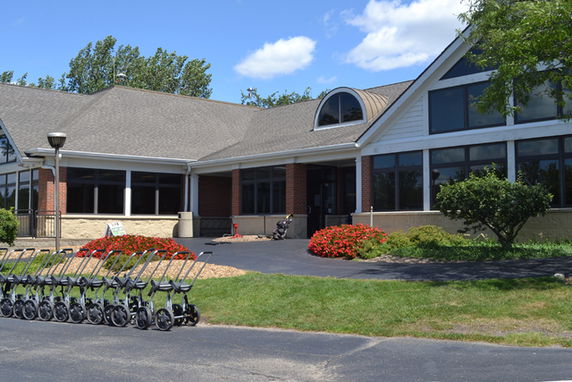 Front view of a building with large windows and a gabled roof.