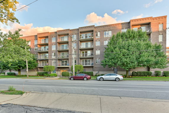 Front view of a multi-story apartment building with balconies.