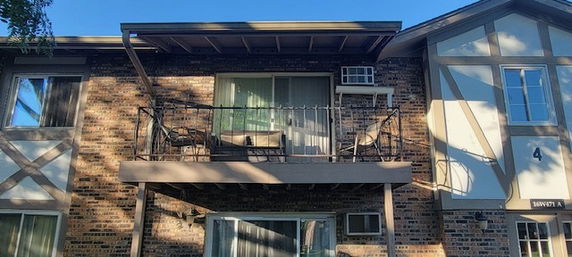 Front view of a two-story brick building with a balcony.