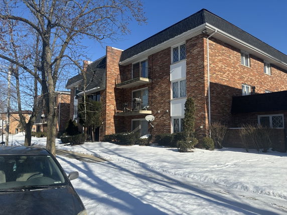 Front view of a multi-story brick building with balconies.