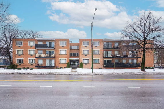Front view of a multi-story brick apartment building.