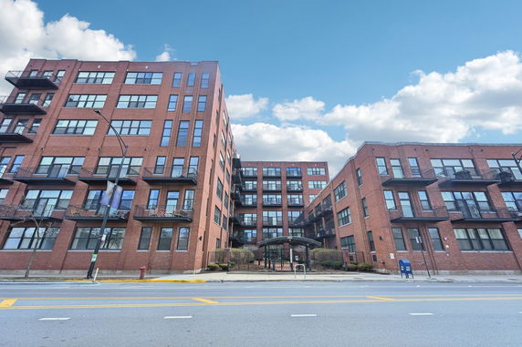 Front view of a multi-story brick building with balconies.