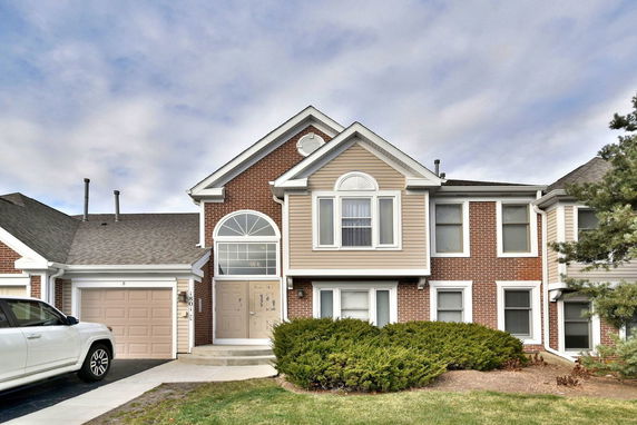 Front view of a two-story house with brick and siding exterior and an attached garage.