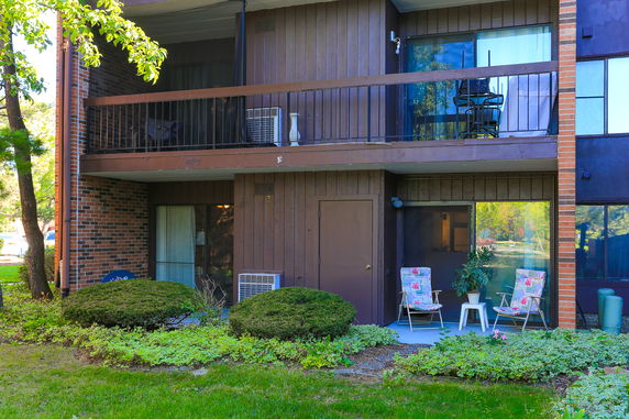 Front view of a two-story residential building with balconies and outdoor seating.