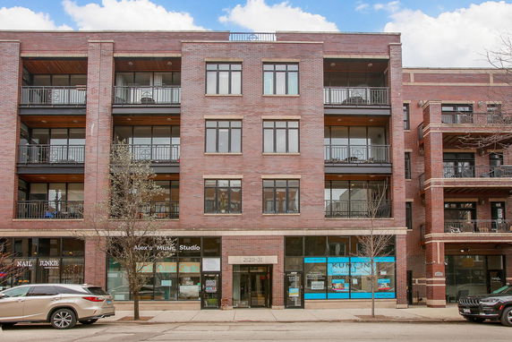Front view of a multi-story brick building with balconies.