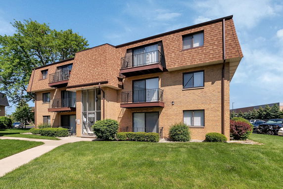 Front view of a multi-story apartment building with balconies.