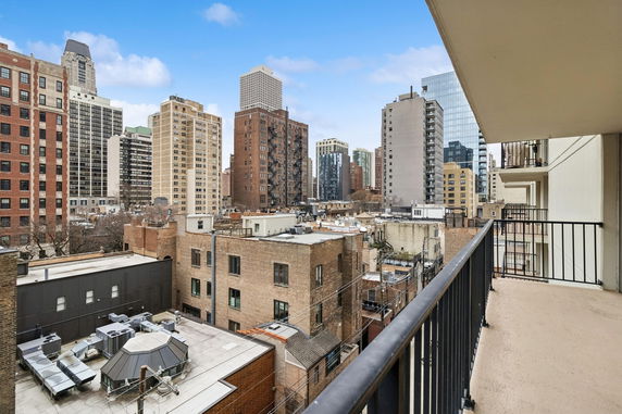 View from a building balcony showing a cityscape with multiple high-rise buildings.