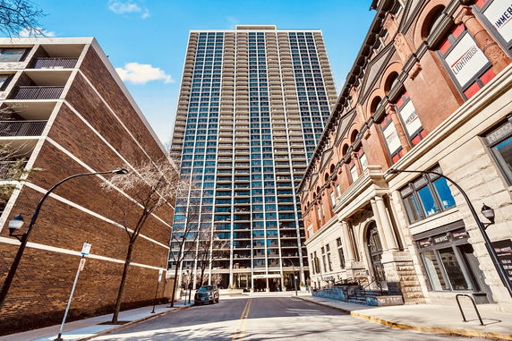 Front view of a tall apartment building with multiple balconies.