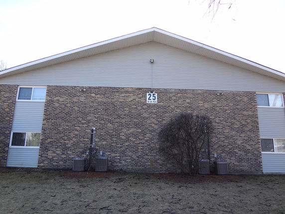 Front view of a building with brick facade and a gable roof.