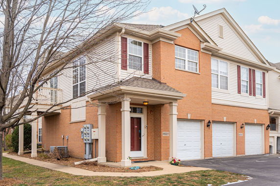 Front view of a two-story house with a brick exterior and three-car garage.