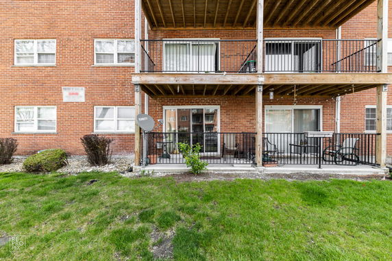 Front view of a brick apartment building with balconies.