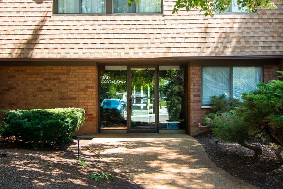 Front view of a two-story building with brick exterior and glass entrance door.