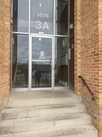 Entrance view of a building with a glass door and brick exterior.