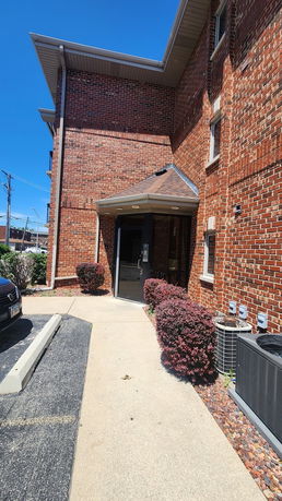 Front view of a brick building with a covered entrance.
