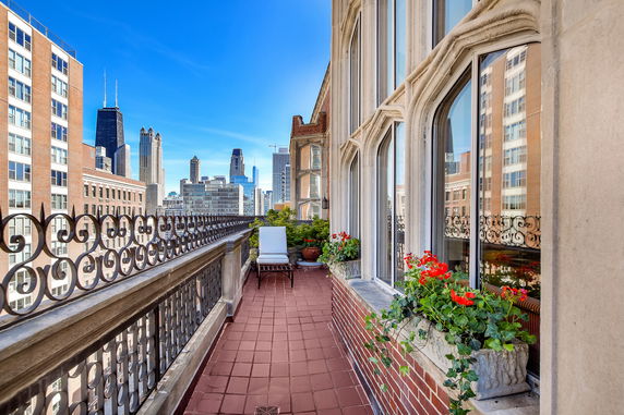 Balcony view with city skyline in the background and decorative railings.
