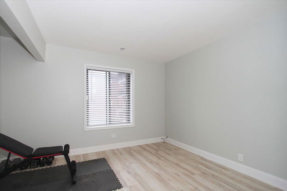 Minimalistic indoor area with an exercise bench and weights.