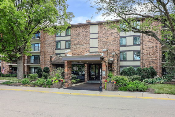 Front view of a multi-story brick building with sheltered entrance.