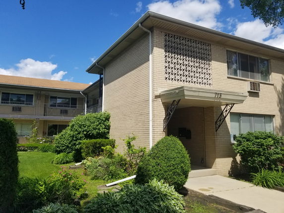 Front view of a two-story apartment building with a covered entrance.