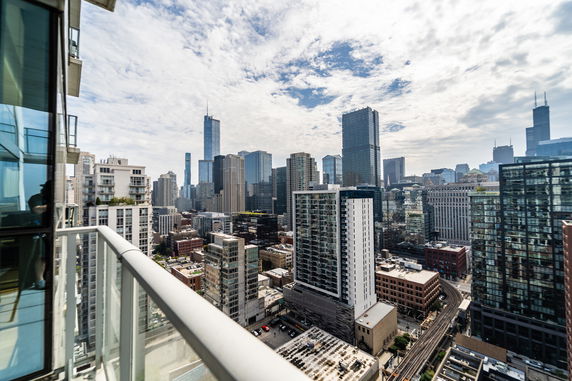 Panoramic view of a cityscape with tall buildings and a cloudy sky.