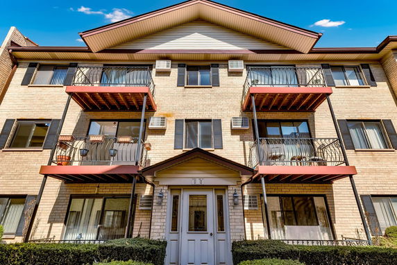 Front view of a three-story apartment building with balconies.