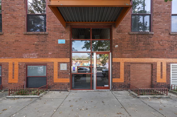 Front view of a brick building entrance with glass doors.