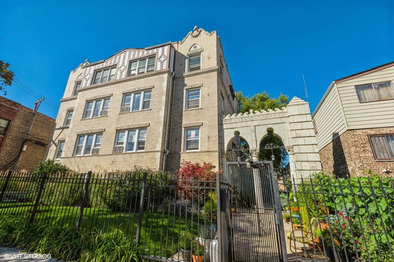 Front view of a multi-story brick building with decorative stonework.