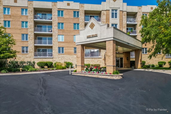 Front view of a multi-story building with balconies and a covered entrance.