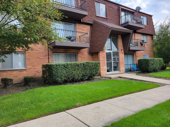 Front view of a three-story apartment building with balconies.