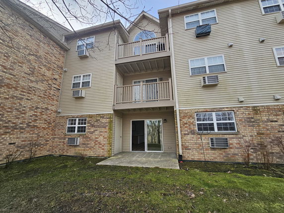 Front view of a multi-story residential building with balconies and brick exterior.