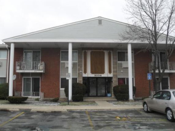 Front view of a two-story apartment building with white columns.