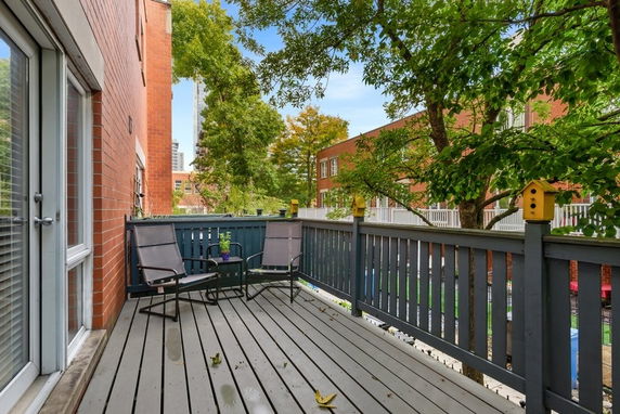 Outdoor deck area with view of surrounding buildings and trees.
