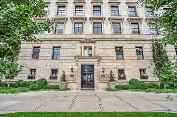 Front view of a multi-story building with detailed architectural elements and decorative plants.