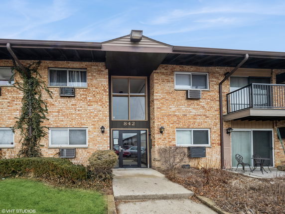 Front view of a two-story brick apartment building with balconies.