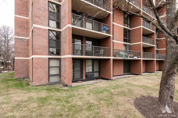 Front view of a multi-story brick apartment building with balconies.