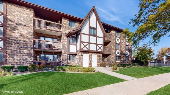 Front view of a multi-story building with a Tudor-style facade and balconies.