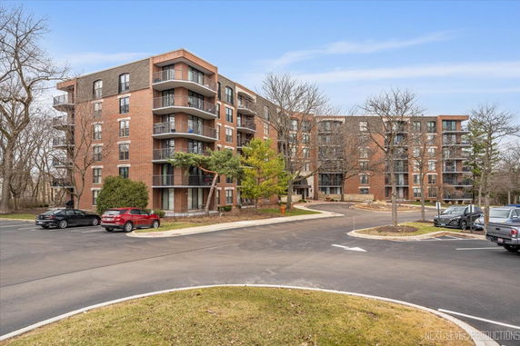 Front view of a multi-story brick apartment building with balconies.