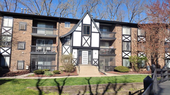 Front view of a multi-story apartment building with a distinct geometric facade and balconies.