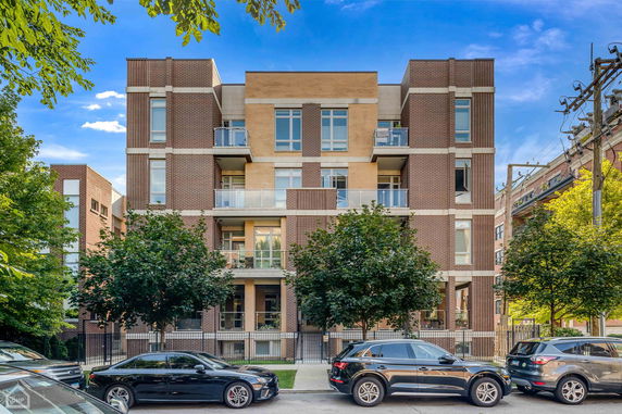 Front view of a modern multi-story apartment building with balconies.