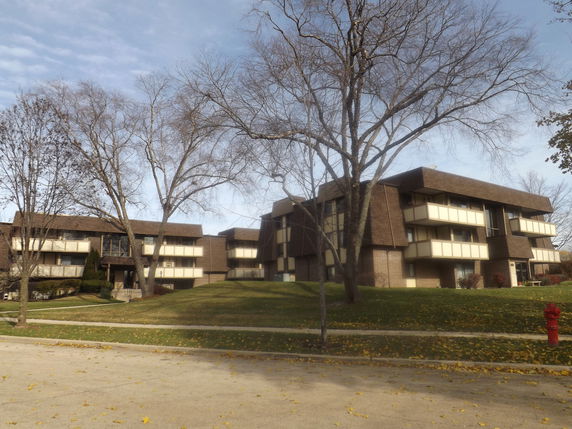 Front view of a multi-story apartment building with balconies.