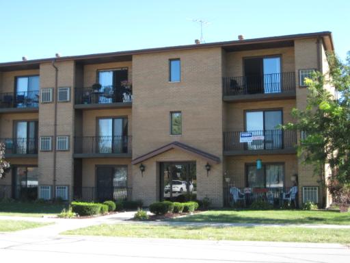 Front view of a three-story apartment building with balconies.