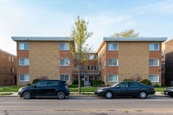 Front view of a three-story apartment building with a flat roof.