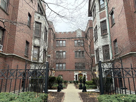 Front view of a brick apartment building with multiple stories.