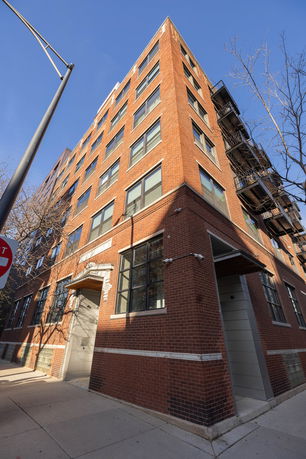 View of a multi-story brick building with numerous windows.