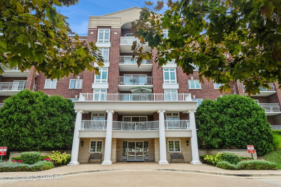 Front view of a multi-story brick building with balconies and white columns.