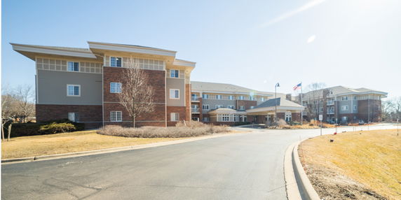 Front view of a multi-story building with a driveway and entrance.