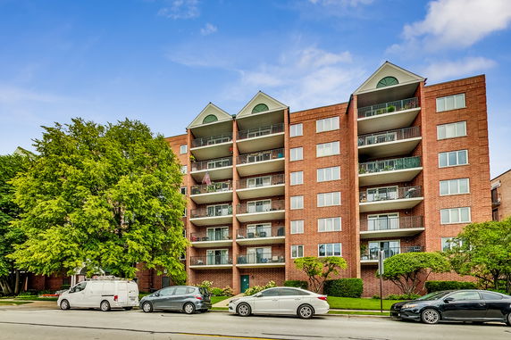 Front view of a multi-story apartment building with balconies.