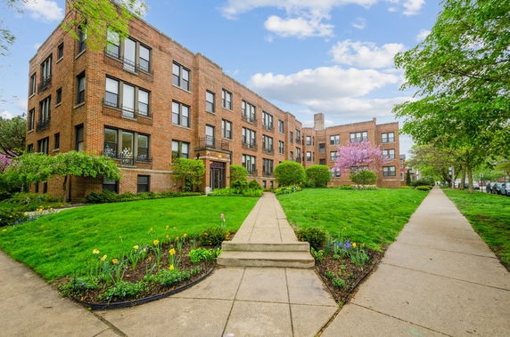 Front view of a brick apartment building with multiple floors.