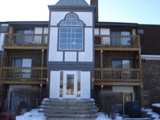 Front view of a multi-story building with balconies and a central entrance.