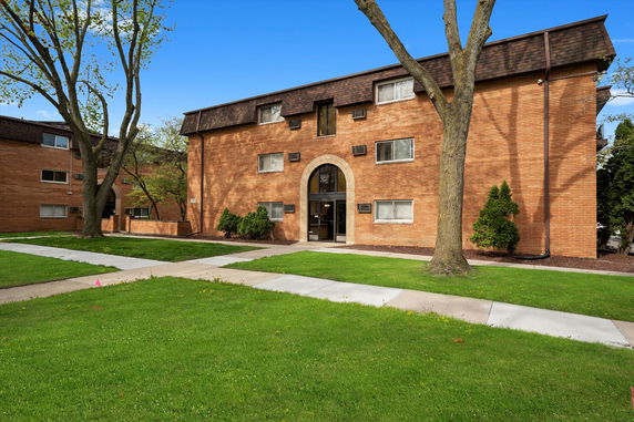 Front view of a three-story brick apartment building with a central entrance.