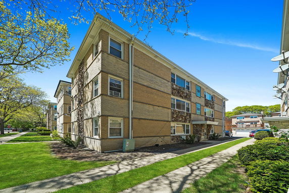 Front view of a multi-story apartment building with brick facade.